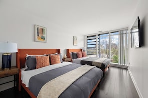 A hotel room with two beds, a large window, and a flat-screen TV. - Luxury 4BR Home, King Bed, Sleeps 12 with Parking! (Toronto)