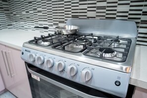 A kitchen with a stainless steel stove, a microwave, and a built-in oven.
