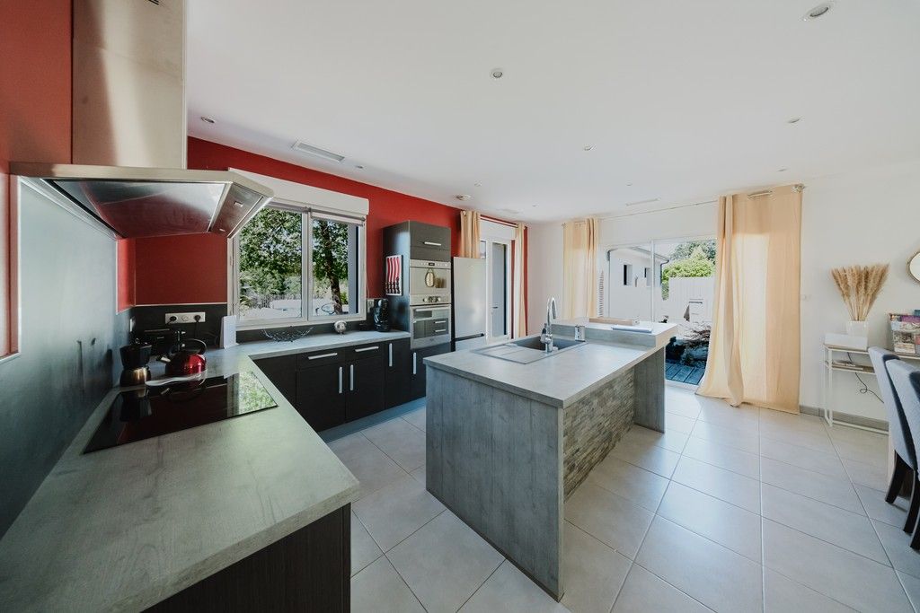A modern kitchen with a central island, built-in appliances, and a view to the outdoors.