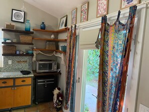 A kitchen with a microwave, a dog, and a dog leash. - Cute private cottage in Santa Paula with Views (Santa Paula)