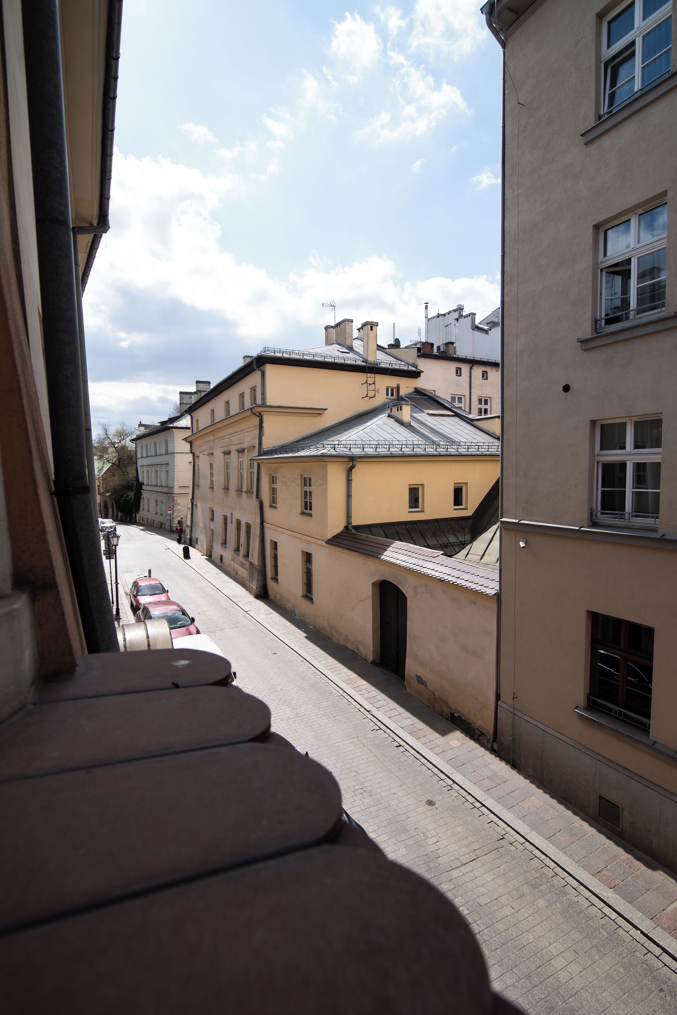 A street view with buildings, a clear sky, and a tram line.