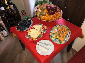 Una mesa con platos de comida y una cesta de frutas.