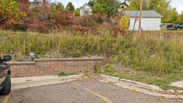 A parking lot with a brick wall and a sign indicating a parking rate.