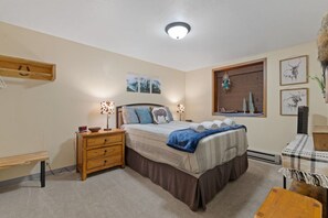 Una camera da letto con un letto, comodini, una cassettiera, una finestra con vista e decorazioni alle pareti.