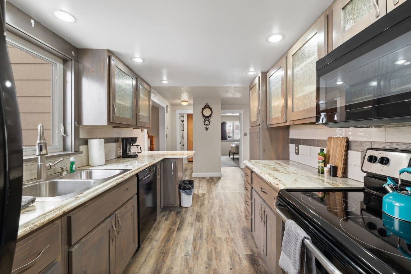 A modern kitchen with a central island, stainless steel appliances, and wooden cabinetry.
