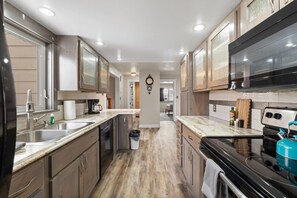 Una cocina moderna con una isla central, electrodomésticos de acero inoxidable y muebles de madera.
