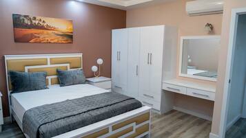 A bedroom with a bed, nightstands, a wardrobe, and a mirror.