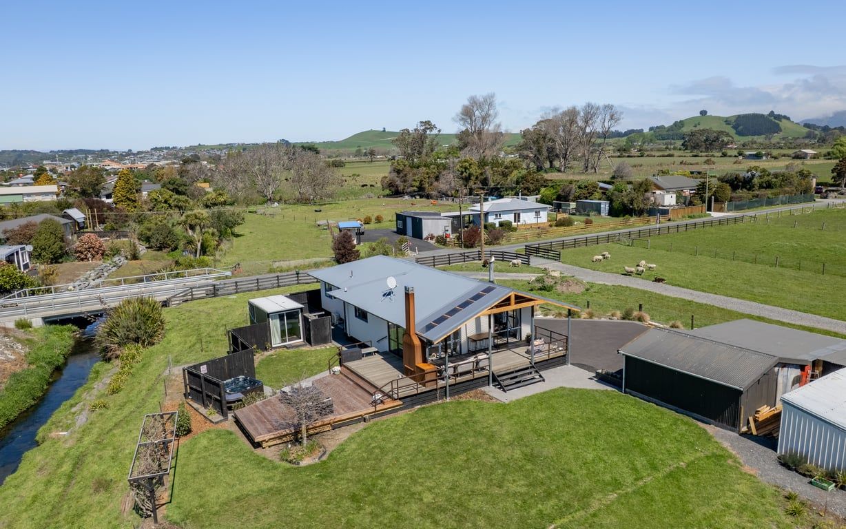 Une maison moderne dotée d’une grande terrasse, d’un garage et d’une cour clôturée.
