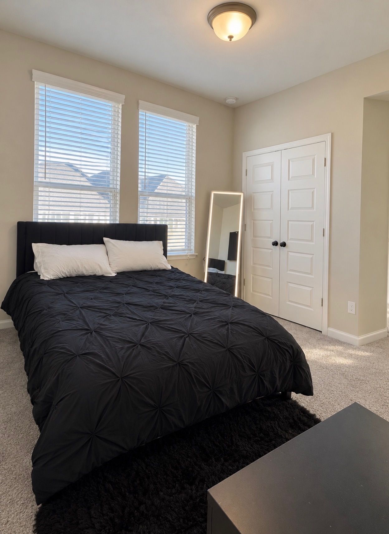 Une chambre à coucher avec un lit, un miroir et une armoire.