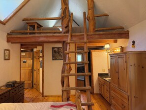 Ein Schlafzimmer im Loft-Stil mit Holzlade, Holzmöbeln und schrägem Dach.