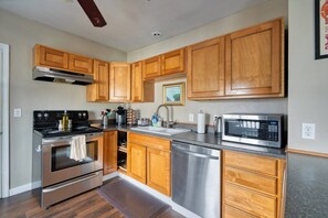 Une cuisine moderne avec des meubles en bois, des appareils en acier inoxydable et un plan de travail en granit.