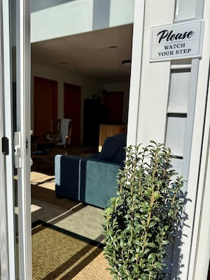 A doorway with a sign that reads 'Please Watch Your Step' and a potted plant in the foreground. - Gorge Landing Spot: Private Couples’ Suite, Mountain Views & Firepits (Stevenson)