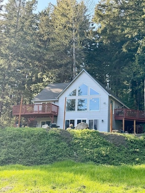 A two-story house with a balcony, surrounded by dense forest. - Gorge Landing Spot: Private Couples’ Suite, Mountain Views & Firepits (Stevenson)