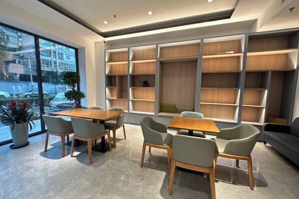 A modern interior with a dining area, seating, and built-in shelving. - Jiahe Liyuan Hotel (Beijing Tongren Hospital Beijing Railway Station) (Beijing)