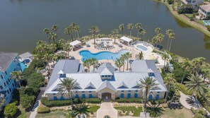 Un resort con una grande piscina, palme e un edificio dalla facciata blu.