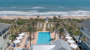 A resort with a pool, beach access, and palm trees. - Golf Views, Pool & Private Beach Access (Palm Coast)