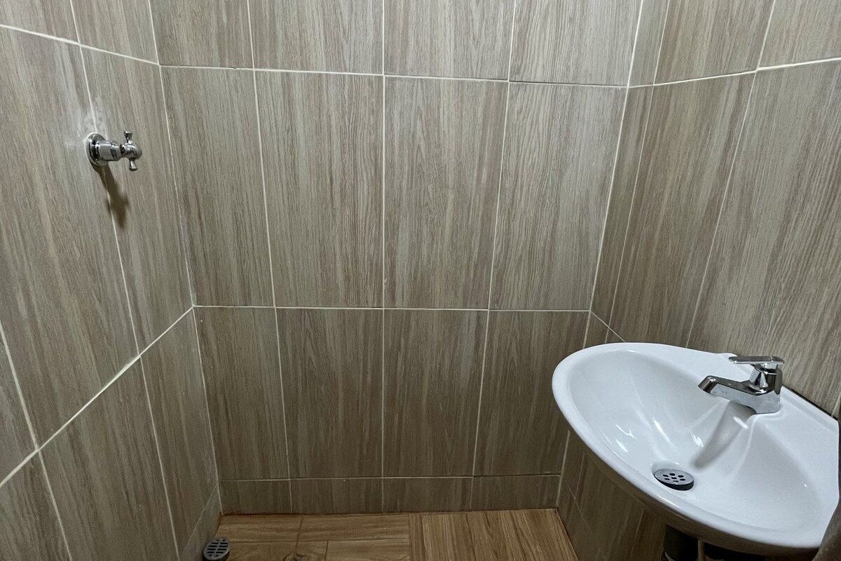 A bathroom with a shower, a sink, and a toilet.