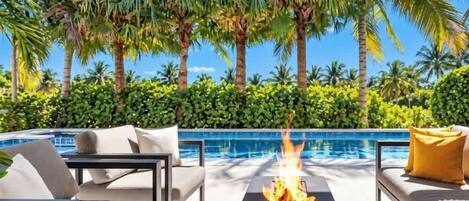 South facing pool area with Fire Pit/ Outdoor Patio with Dining, Heated Pool & Hot Tub.