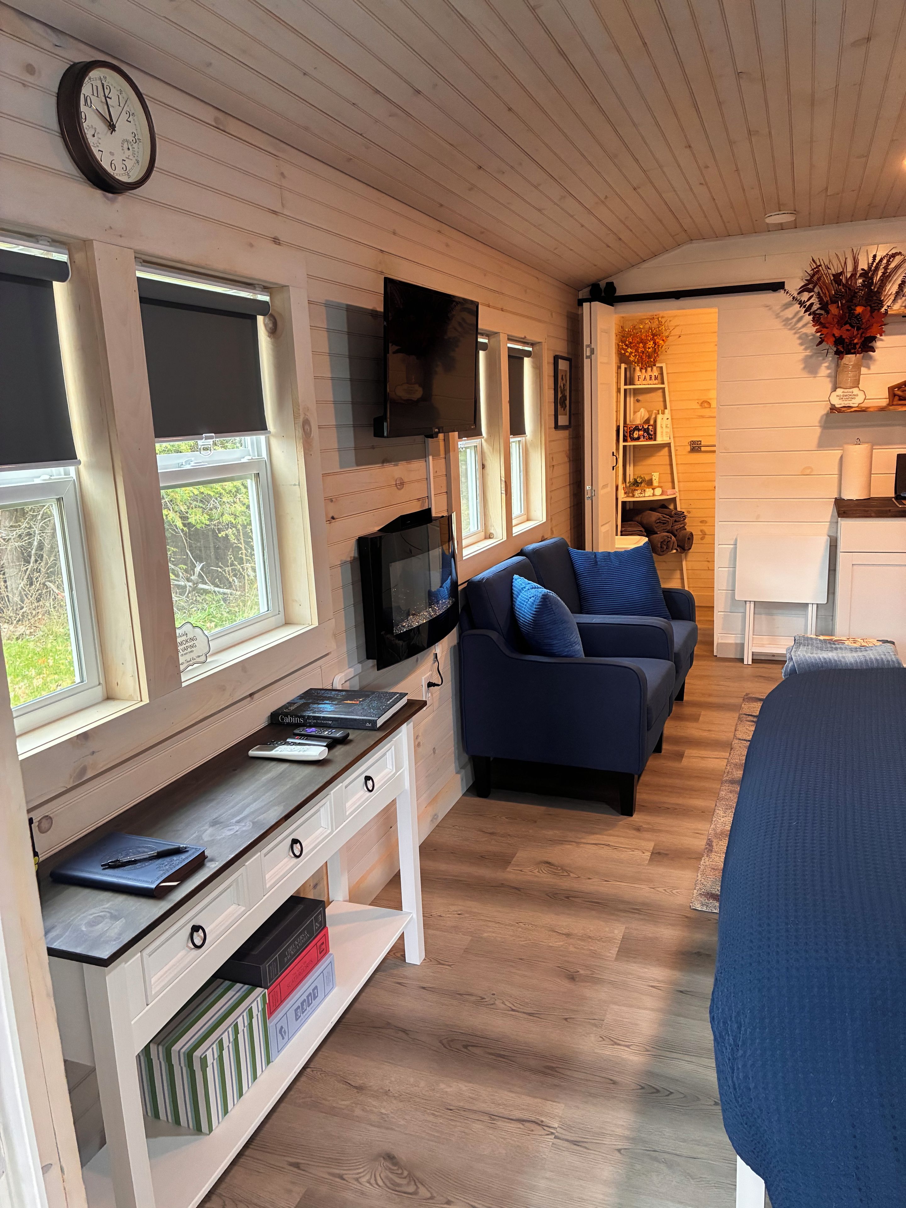Una sala de estar acogedora con televisor, sofá y escritorio con computadora y libros.
