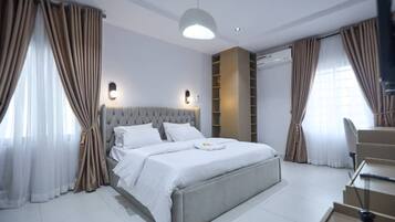 Un dormitorio moderno con una cama grande, una estantería empotrada y una escalera.