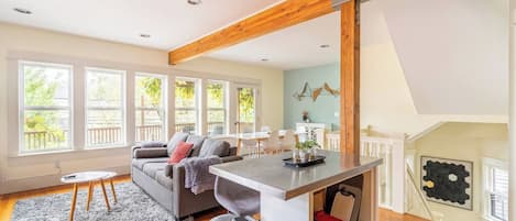 A spacious living area with a sofa, a coffee table, and a kitchen island.