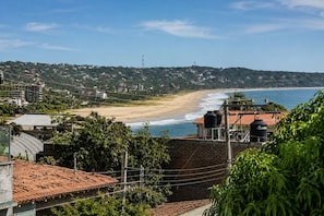 Une vue sur la côte, avec une plage, des bâtiments et de la végétation.
