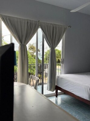 Une chambre avec un lit, une table et une vue sur l’extérieur grâce à une porte coulissante.