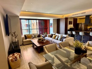 A modern living room with a sofa set, a coffee table, and a glass dining table. - Family 3BR Terrace · Pool & Gym · Zona Americana (Guadalajara)