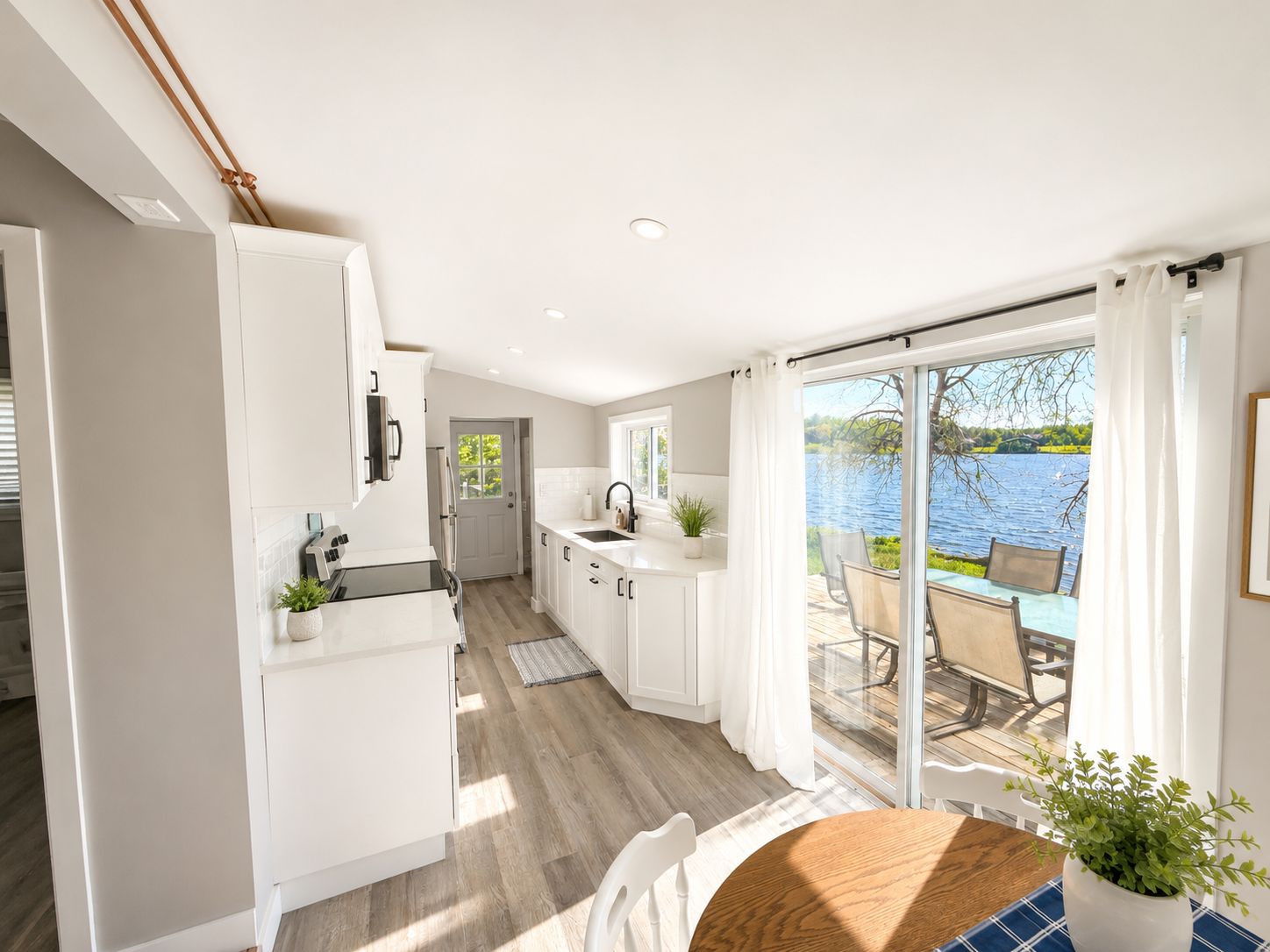 Une cuisine moderne donnant sur un lac, avec de grandes portes-fenêtres coulissantes.