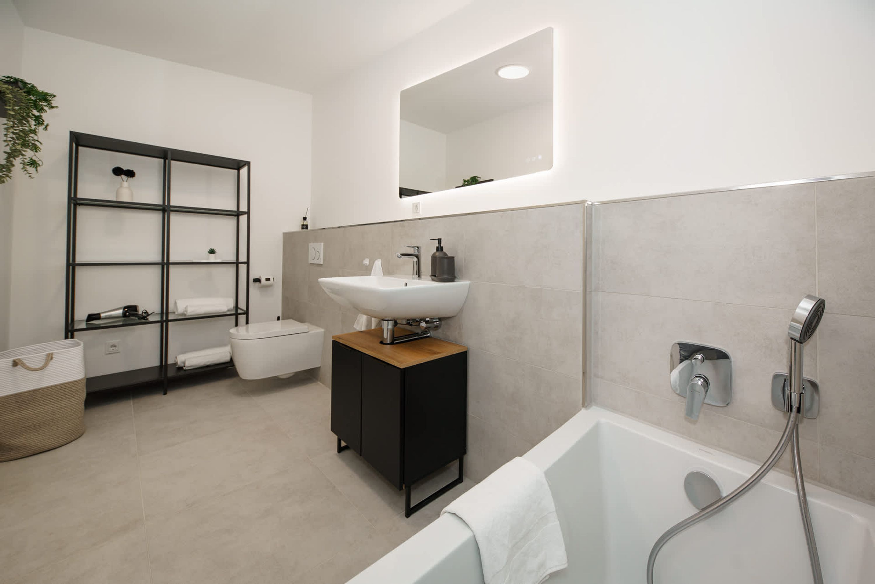 A modern bathroom with a toilet, sink, and bathtub.