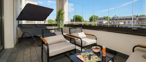 Een balkon met twee stoelen, een tafel en een tijdschrift.