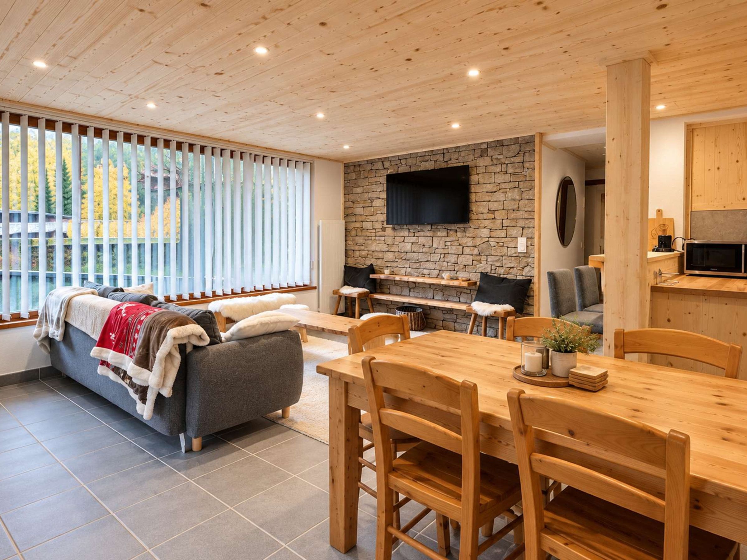 A modern interior with a stone wall, wooden furniture, and a flat-screen TV.