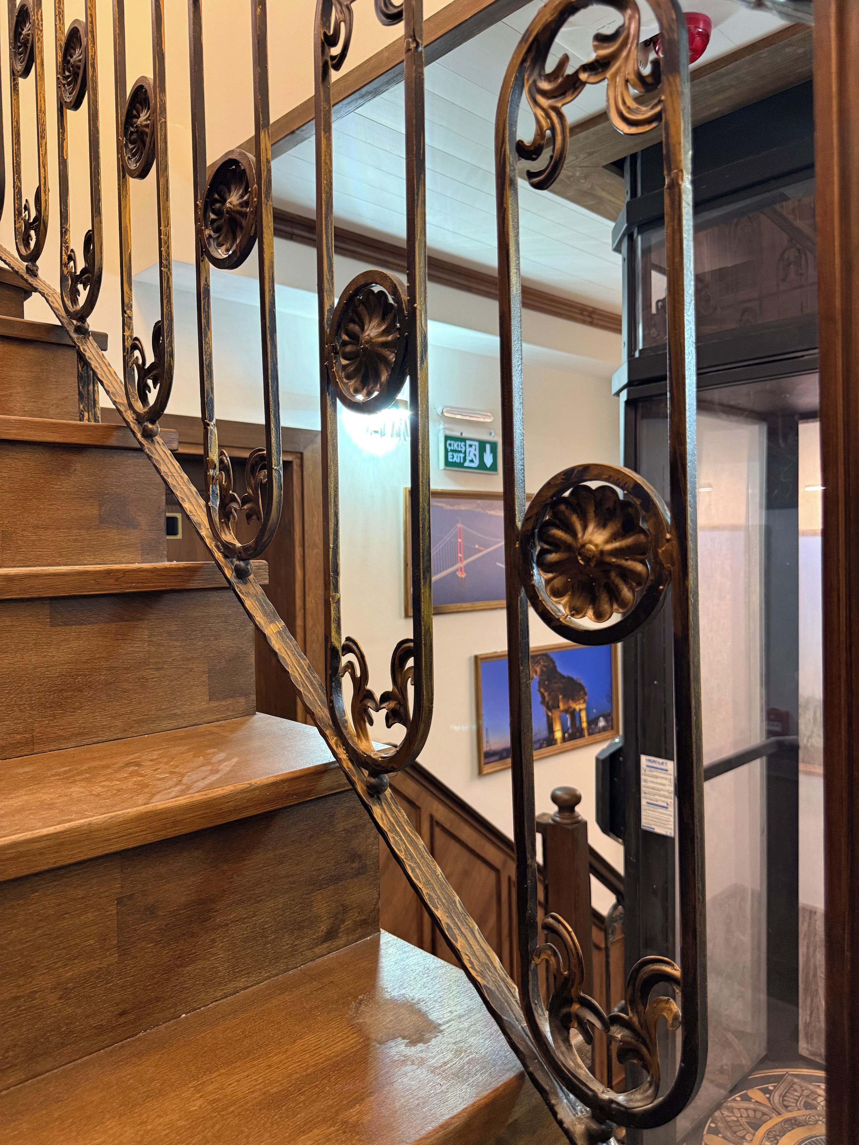 Una escalera de madera con barandillas de metal decoradas.