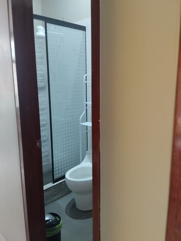 A bathroom with a toilet, a shower enclosure, and a trash bin. - Fabulosa casa residencia, en santa maria del valle - HUANUCO con areas verdes (Huánuco)