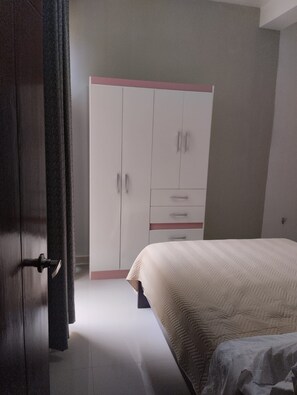 Un dormitorio con una cama, un armario y una puerta.