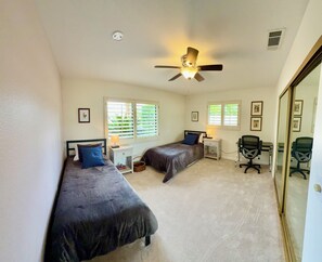 A bedroom with two beds, a desk, a chair, and a ceiling fan. - Olive Tree Oasis ~ Charming 3B Indian Wells Home (Indian Wells)