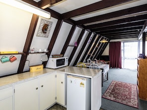A compact kitchen with a microwave, a bread box, and a small refrigerator. - The Mountain Nook -  Ohakune Holiday Home (Ohakune)