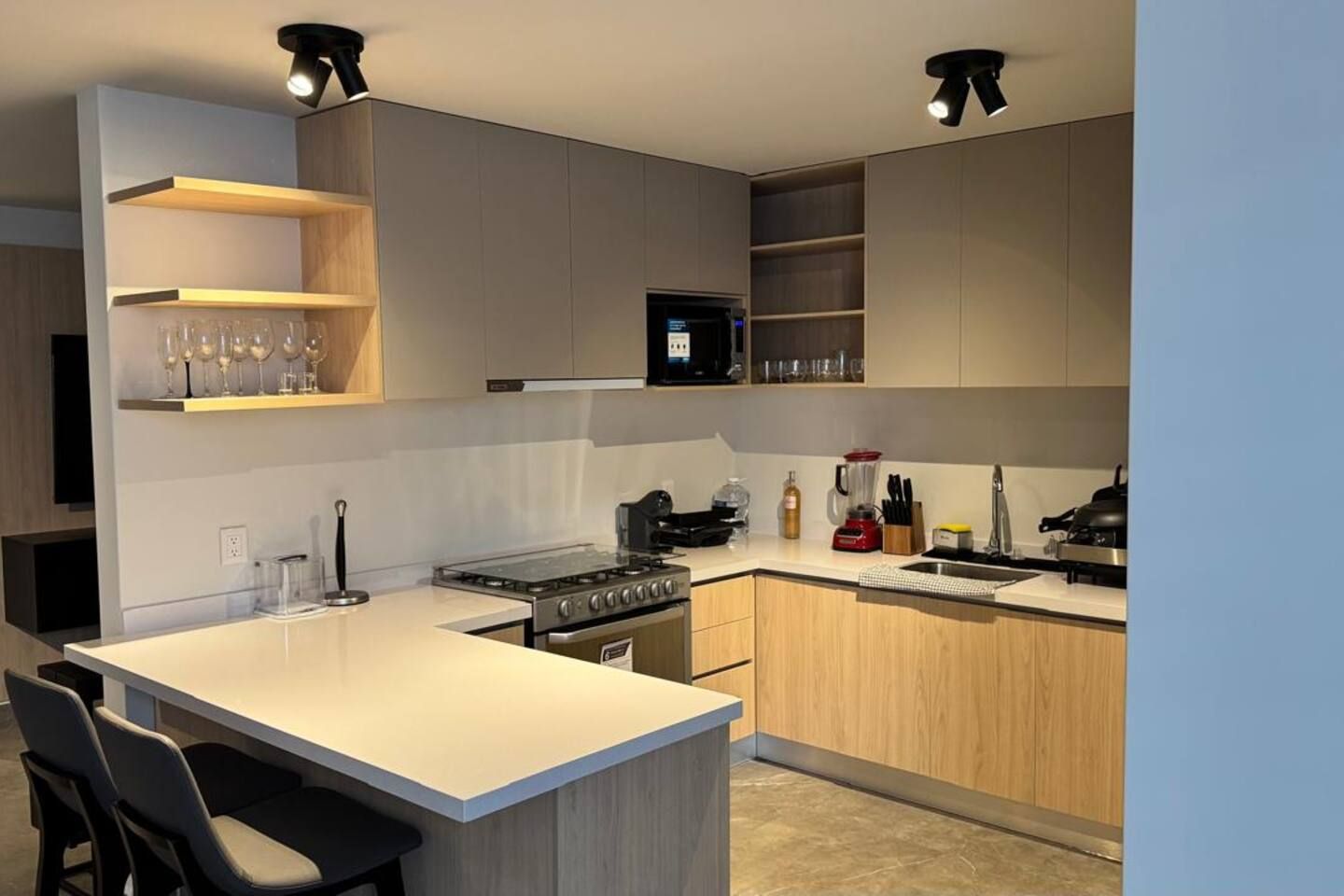 A modern kitchen with a central island, built-in appliances, and ample storage.