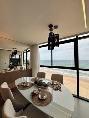 A modern dining area with a view of the beach. - New Listing (Ipojuca)