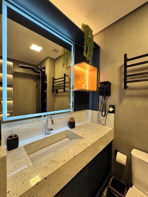 A modern bathroom with a large mirror, a sink, a toilet, and a towel rack. - New Listing (Ipojuca)