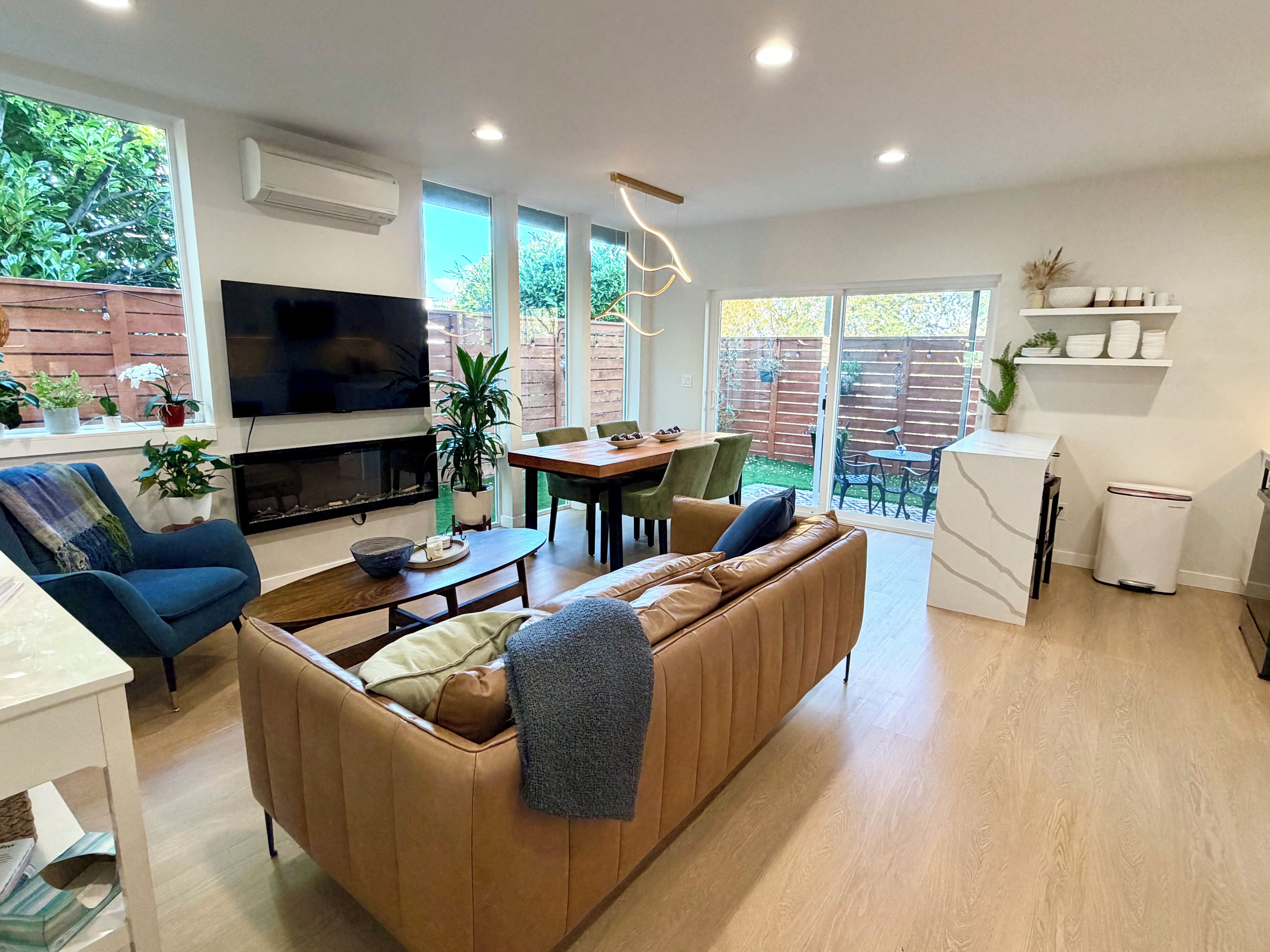 A modern living room with a sofa, television, and dining area.