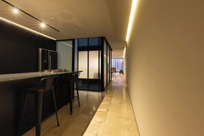 Une cuisine moderne dotée d’un bar, d’un espace repas et offrant une vue sur le paysage urbain grâce à de grandes fenêtres.