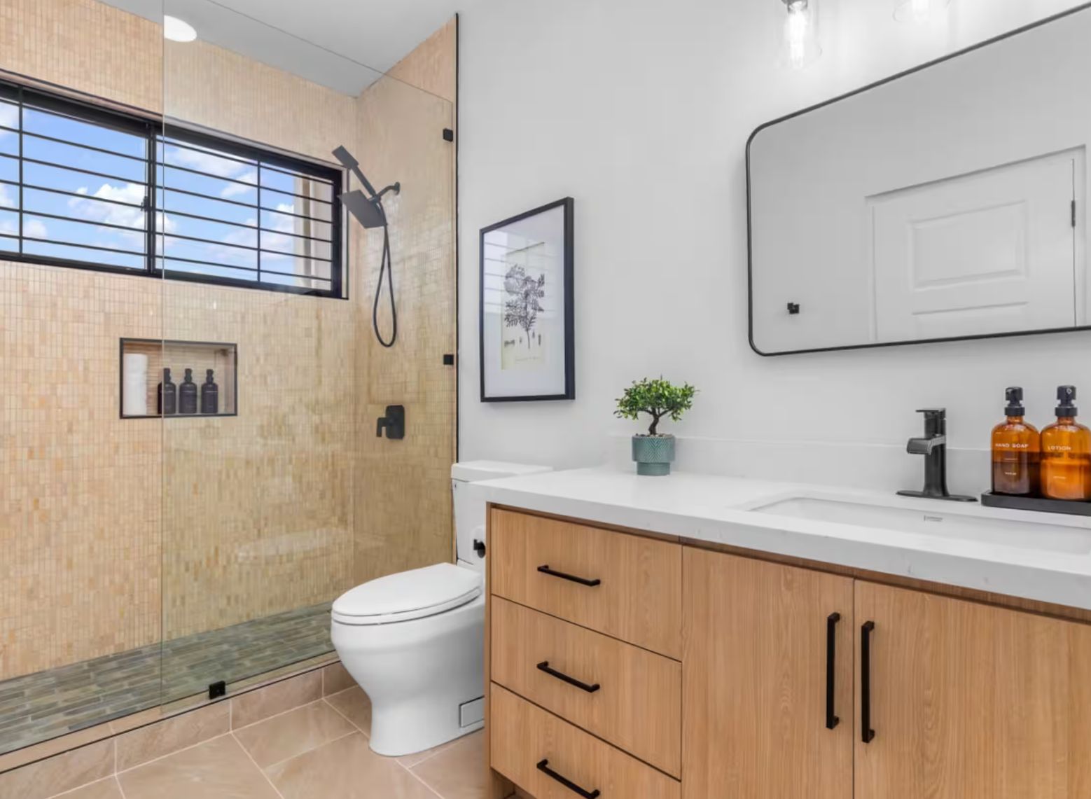 Une salle de bain moderne équipée de toilettes, d’une douche et d’un meuble-lavabo.