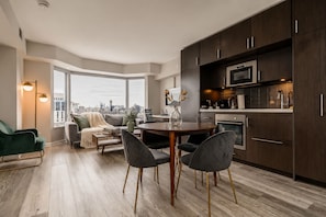 Un apartamento moderno con comedor, cocina y un amplio ventanal con vistas a la ciudad.