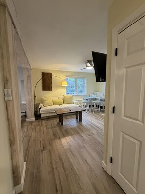 Ein Wohnzimmer mit einer Couch, einem Couchtisch und einem Essbereich mit Stühlen und einem Tisch.