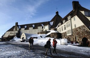 Ein Gebäude mit einer steinernen Fassade und mehreren Schornsteinen, umgeben von Schnee.