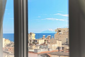 A coastal cityscape with buildings and a mountain in the distance.