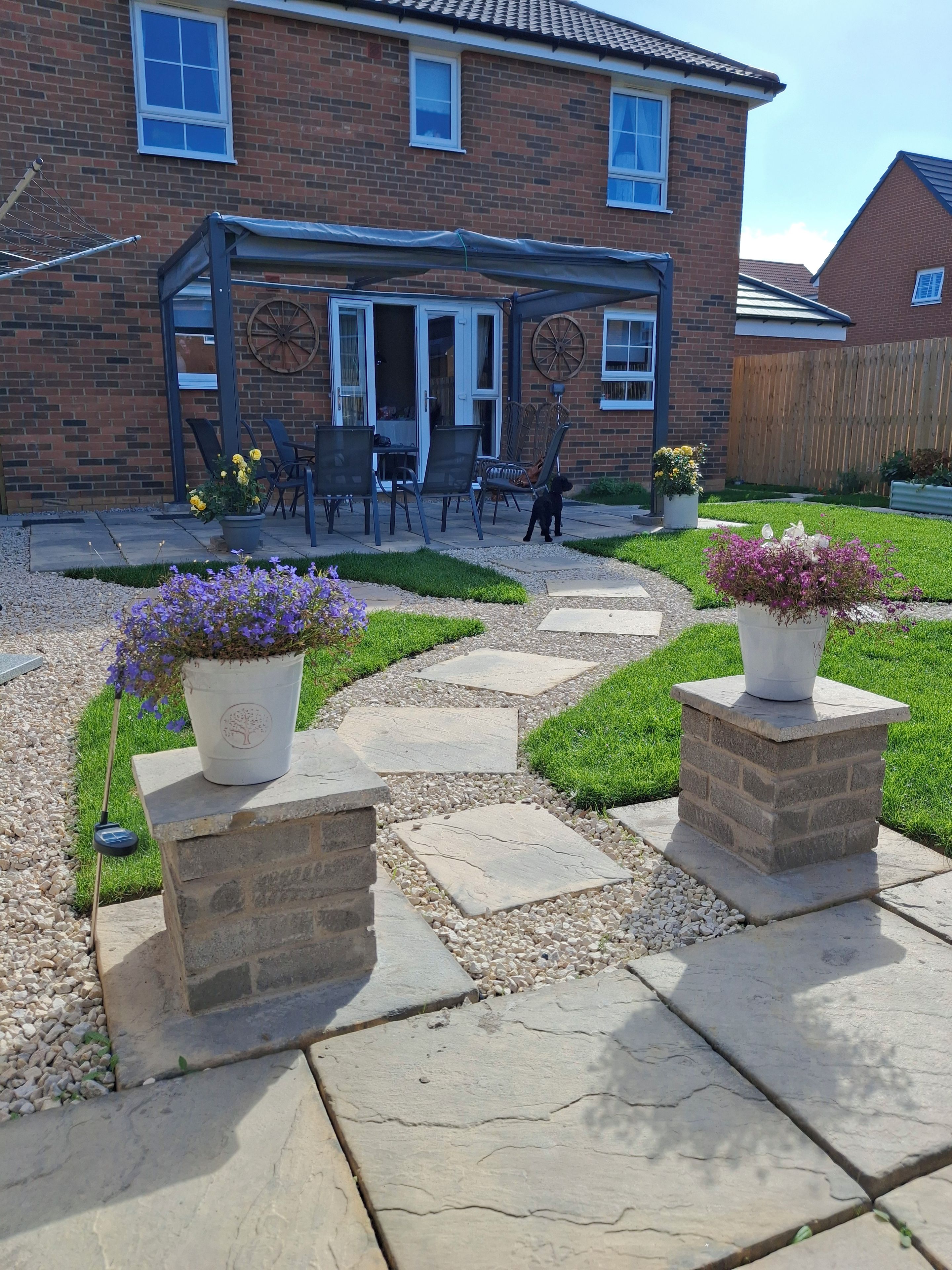A brick house with a patio area featuring outdoor furniture and potted plants.