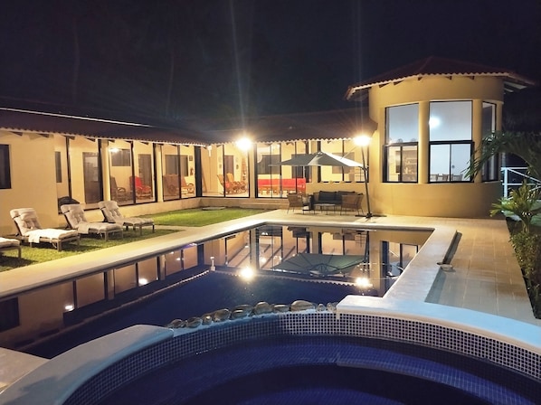 A swimming pool with a hot tub, lounge chairs, and a covered patio area. - New Listing (Amatecampo)