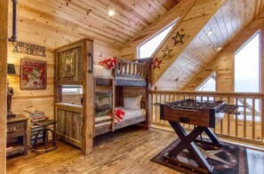 Un interno accogliente con un letto a castello, un tavolino e una griglia.